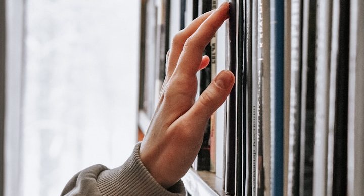 Bid Library Bid writer reaching for documents stored on a bid library shelf.